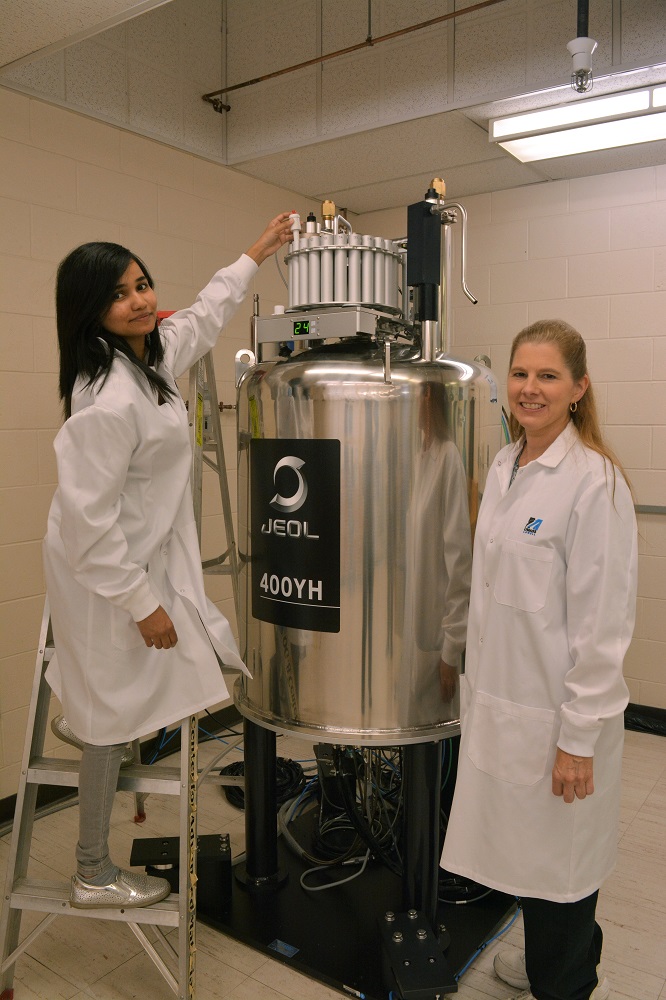 Graduate student Liyanage loading a sample into the NMR